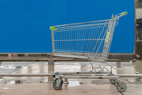 Minimalisme stijl, Shopping cart en blauwe muur. — Stockfoto