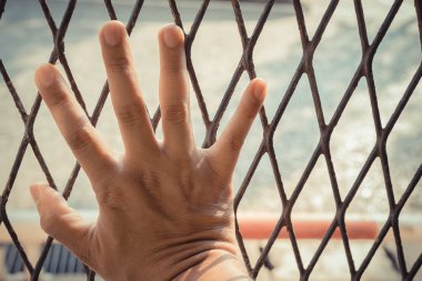 Çelik kafes üzerinde adamın ellerini yakın çekim