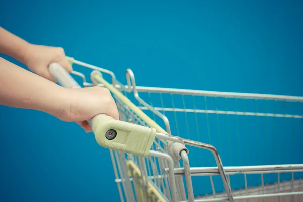 Minimalism style, Shopping cart and blue wall and human hand.