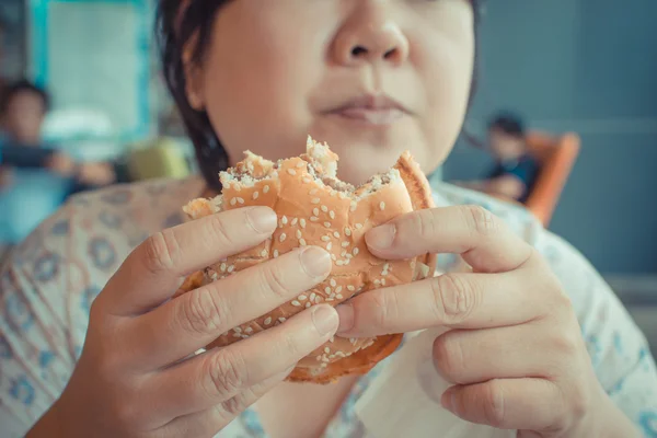 Asie žena jíst hamburger — Stock fotografie