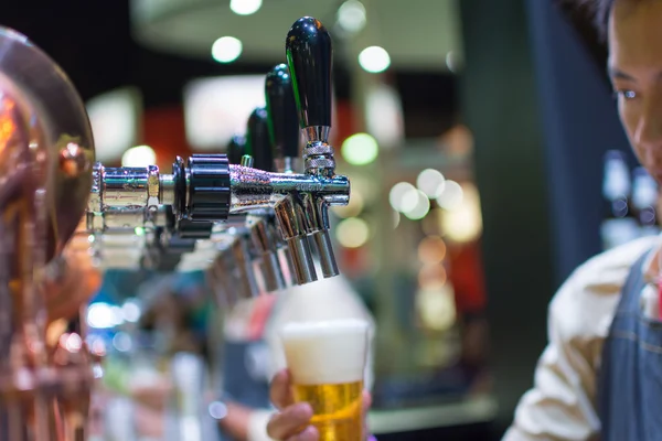 Barman of barman gieten een tapbiertje pils van bier kraan — Stockfoto