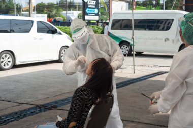 Bangkok, Tayland - 17 Mayıs 2020: PPE kostümlü tanımlanamayan doktor ve COVID-19 tarafından kontrol edilen Asyalı hasta burun ve ağızdan alınan burun ve orofaringeal örnekleri