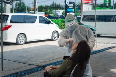 Bangkok, Tayland - 17 Mayıs 2020: PPE kostümlü tanımlanamayan doktor ve COVID-19 tarafından kontrol edilen Asyalı hasta burun ve ağızdan alınan burun ve orofaringeal örnekleri