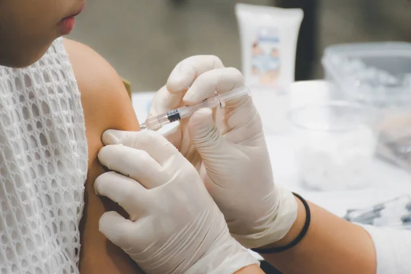 患者アジアの女性の健康診断は 毎年厚生省によってインフルエンザに対してワクチン接種を受けることによって — ストック写真