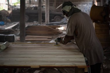 Bangkok, Tayland - 1 Mayıs 2020: Tanımlanamayan marangoz, depodaki doğal ahşaptan mobilya ya da kereste ya da ahşap fabrikasından inşaat ya da satış için kereste üretiyor.