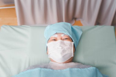 Kaş dövme kliniğinde ya da Kaş nakış kliniğinde çalışan doktor tarafından yapılan Asyalı kadın kaş dövmesi dövmesi. Dövme ve düzeltme için KOVID-19 önleme politikası kullanın.