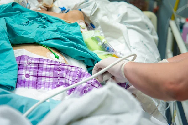 患者アジアの高齢女性80病院のベッドで医師が使用する超音波機器による超音波医療検査 — ストック写真