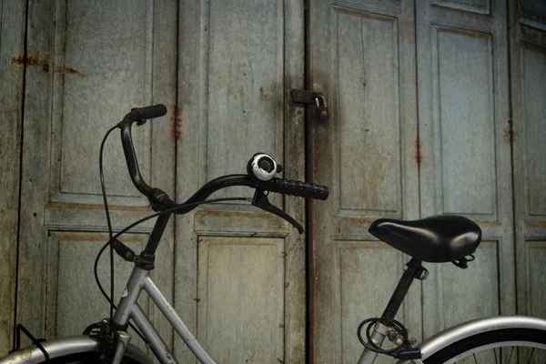 Bicycle and wood door — Stock Photo, Image