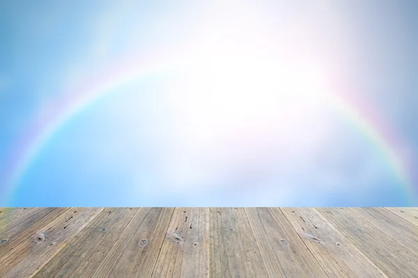 Terraza de madera y cielo borroso con arco iris — Foto de Stock