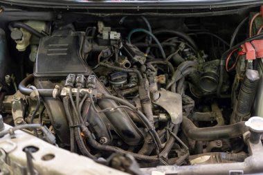 Otomotiv motor bölmesini emme manifoldları ve gaz pedallarıyla kapatın. Otomotiv bakım onarımı ve araç servisi atölyesinde mekanik denetim gösteriliyor.