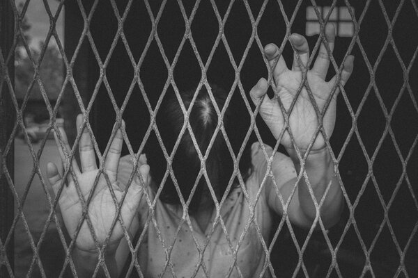 Hands of the woman on a steel lattice close up , vintage  black