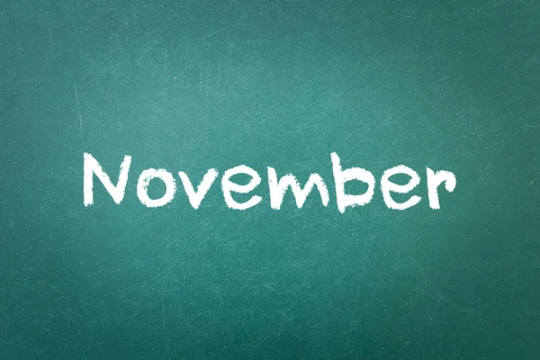 Groene krijtbord muur textuur met een woord November — Stockfoto