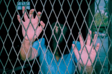 Eller yukarı, vintage tarzı bir çelik kafes yakın kadın