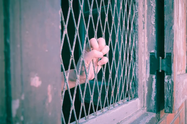 Las manos del hombre en una celosía de acero de cerca, estilo vintage — Foto de Stock