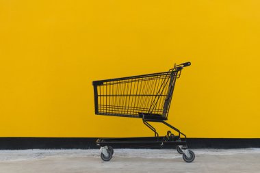 Minimalizm tarzı, alışveriş sepeti ve sarı duvar.