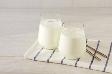 Organik probiyotik kefir ya da arka planda gözlüklü probiyotik yoğurt. Ev yapımı soğuk mayalanmış süt içeceği..