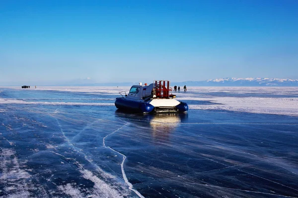 Baykal gölünün donmuş buzlu yüzeyinde hovercraft. Khivus - buzda nakliye. Çatlaklı şeffaf yumuşak buz.