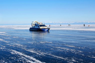 Baykal gölünün donmuş buzlu yüzeyinde hovercraft. Khivus - buzda nakliye. Çatlaklı şeffaf yumuşak buz.