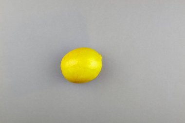 Gri arka planda limon. Pantone 'un 2021 yılı rengi. Aydınlatıcı ve nihai gri.