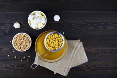 Nohut suyu, akafaba, kuru nohut tohumu ve koyu ahşap arka planda hazırlanmış krema. Vejetaryen tarifi için yumurta nakli. Sağlıklı vejetaryen ürünü. Üst görünüm.