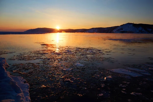 Beau coucher de soleil sur le lac Baïkal au printemps. Fonte de la glace et de l'eau libre dans le lac. — Photo