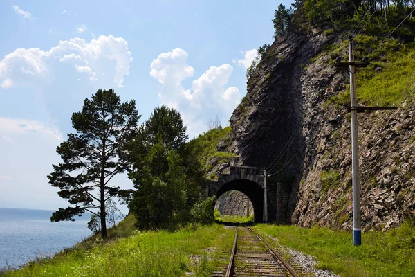 Baikal lake in summer. Old stone arch tunnel in mountain the rock on the Circum-Baikal railway . High quality photo