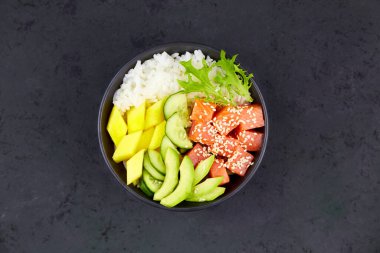 Hawaii ahi 'si, balıklı diyet yemeği. Somon, pirinç, avokado, salatalık, mango, otlar. Üst Manzara. Yakın plan.