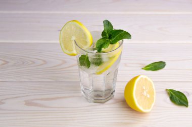 Bir bardak limonata ya da ahşap arka planda mojito. Taze soğuk ferahlatıcı yaz kokteyli limon, nane ve buz ile. 