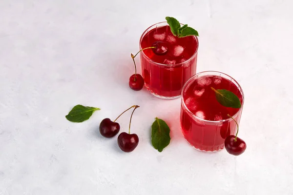 Cherry cocktail with ice and mint on a light grey background. — Stock Photo, Image