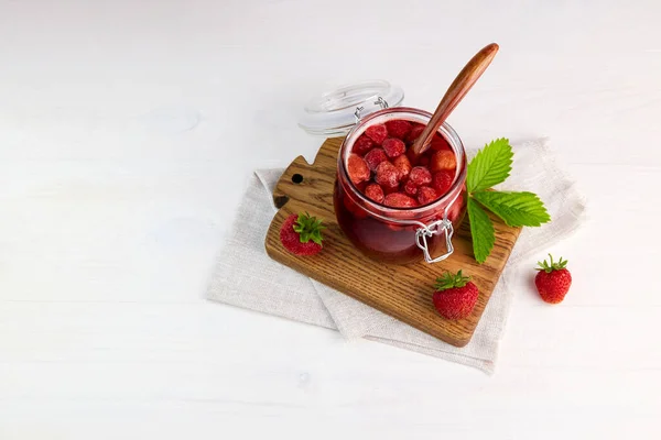 Strawberry jam in a glass jar and fresh berries. Homemade strawberry marmalade. Top view. — Stock Photo, Image