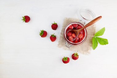 Cam kavanozdaki çilek reçeli ve keten peçete. Ev yapımı çilek reçeli. Üst görünüm.