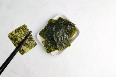 Çubuklarda bir parça kurumuş deniz yosunu var. Nori, yenebilir Japon yosunu, sağlıklı atıştırmalık..