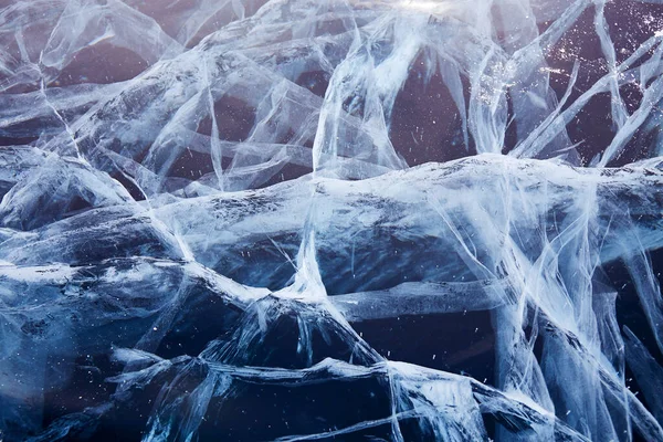 Schönes transparentes blaues Eis mit Rissen. Der Baikalsee im Winter. Natürlicher kalter Hintergrund von Eis — Stockfoto