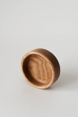 Beyaz arka planda yuvarlak doğal ahşap ürün. Yuvarlak kül ağacı kasesi. Şık çanak çömlek.