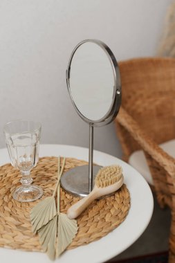 Beyaz bir kozmetik masasında doğal kıllı ayna ve saç fırçası..