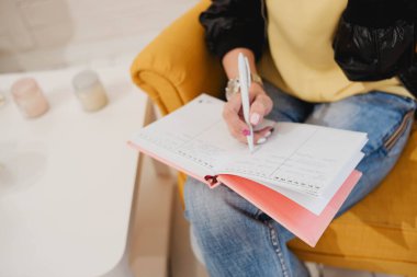 Kız pembe bir not defterine not alıyor. Kot pantolon. İş dünyası