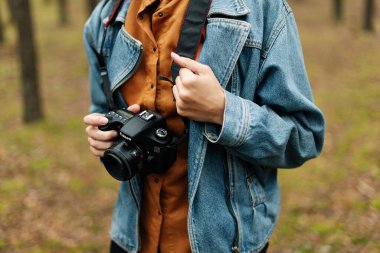 Kameralı bir fotoğrafçı. Kamerayı kapat. Denim ceket.