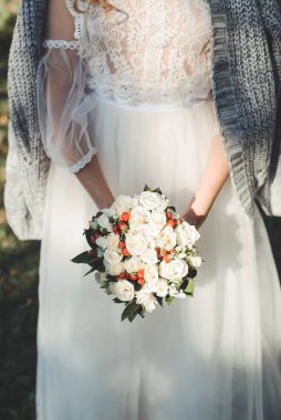Beyaz elbiseli gelin elinde bir düğün buketi tutuyor. düğün töreni