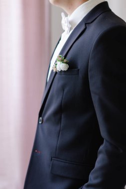 Koyu renk ceketli ve damadın yaka çiçeği. Düğün detayları