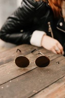 Siyah deri ceketli, yuvarlak güneş gözlüklü, şık insanlar.