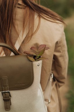 Sırt çantalı, bej ceketli kız.