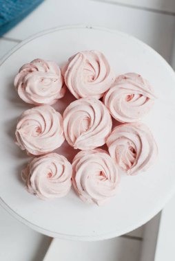 Masanın üzerinde beyaz bir tabakta tatlı pembe krema