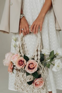 female hands with watch and bag with flowers close up