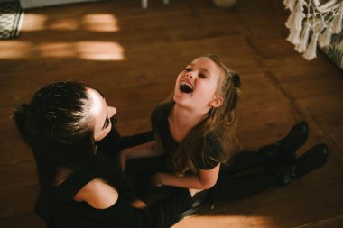 Sevimli küçük kız annesinin önünde kahkahalarla gülüyor