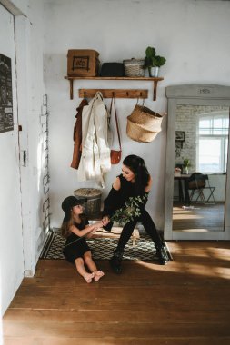 Soyunma odasında siyah elbiseli güzel bir anne ve kız.