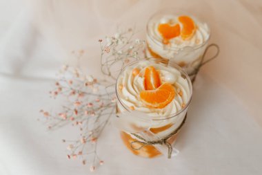 Mandalinayla süslenmiş şeffaf bir fincanda güzel bir dondurma.