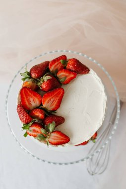 Tepsi manzaralı çilekle süslenmiş kremalı tatlı beyaz pasta.