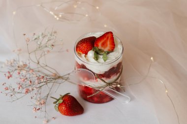 tatlı çilekli puding ve kaşık beyaz masaya yakın