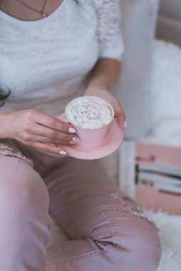 Manikürlü güzel kadın elleri. Kahveli pembe kupayı tut.