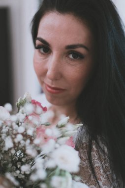 Güzel bir esmer kız yüzü ve taze çiçekler.